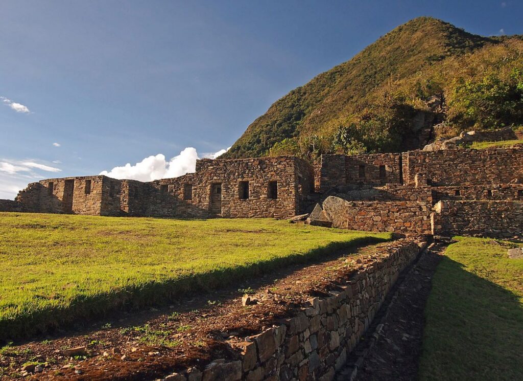 Terrazas y edificaciones de piedra de la ciudadela de Choquequirao envueltas en niebla