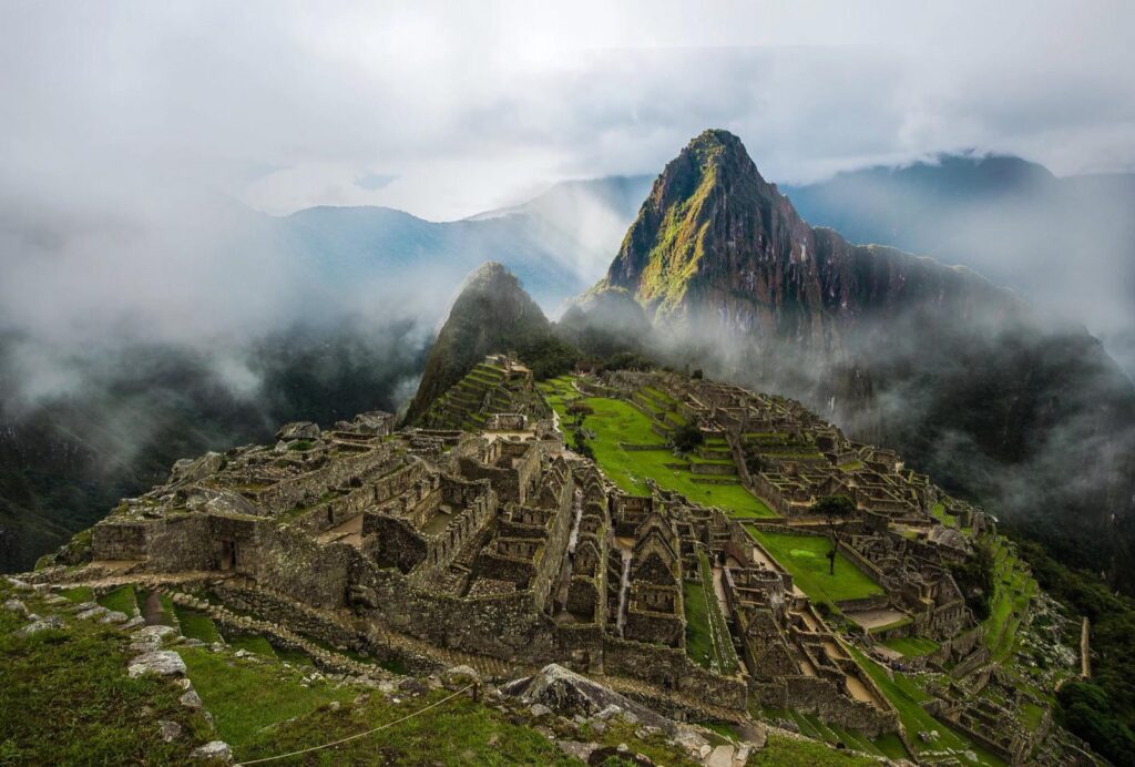 Ciudadela de Machu Picchu entre la neblina de la mañana, con el pico Huayna Picchu al fondo
