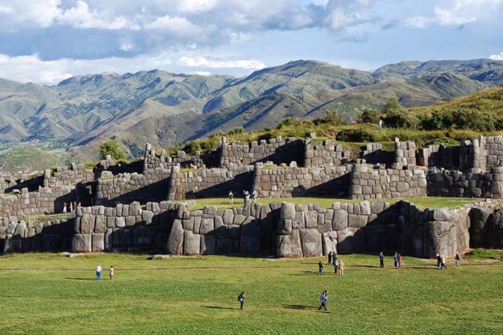 Grupo de viajeros con guía recorriendo un sitio arqueológico cerca de Cusco